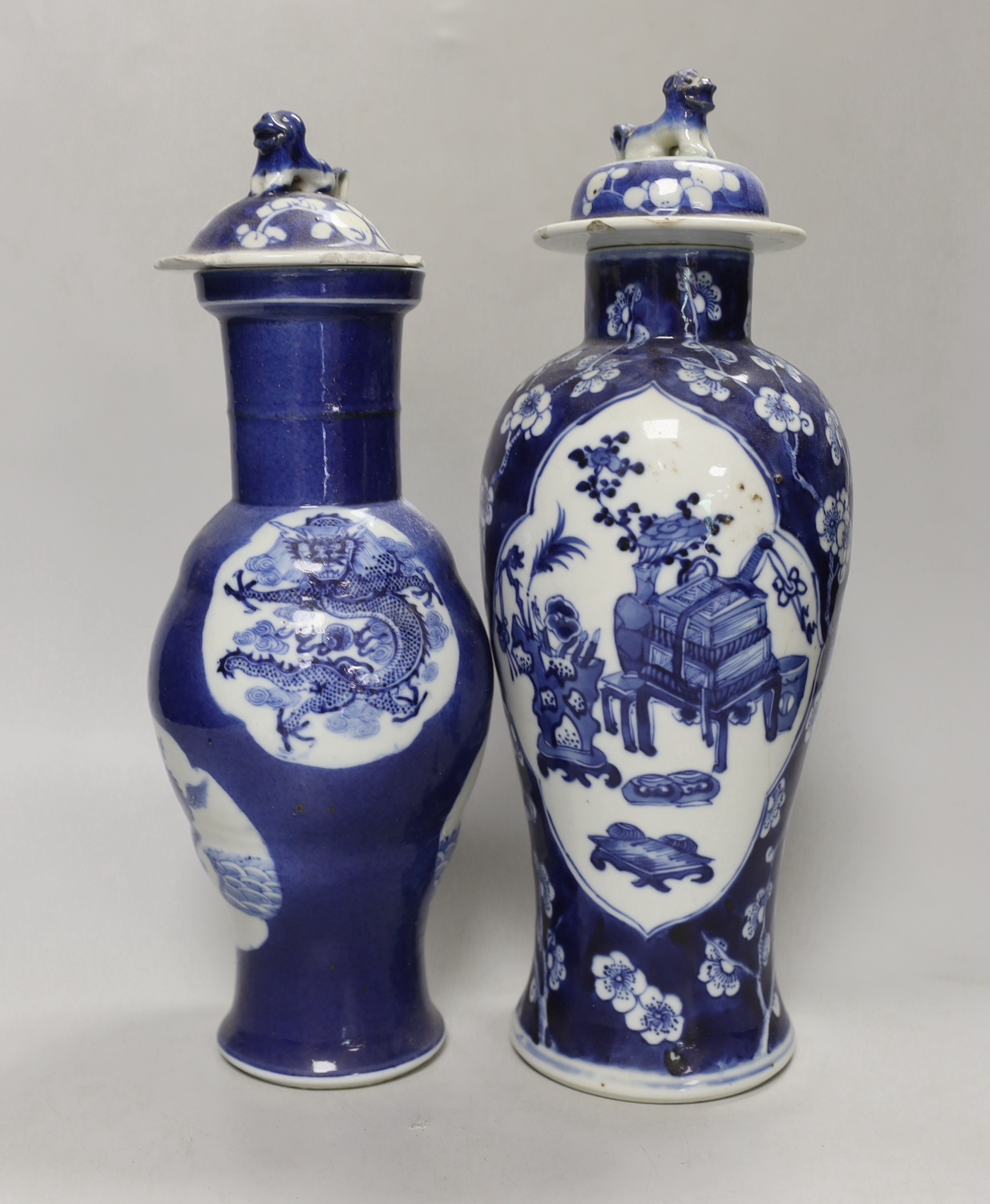 Two 19th century Chinese blue and white vases and covers, one with a dragon cartouche, the other a floral cartouche, tallest 34cm high